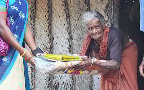 गरीबों और जरूरतमंदों को पीले रंग के कपड़े का दान।